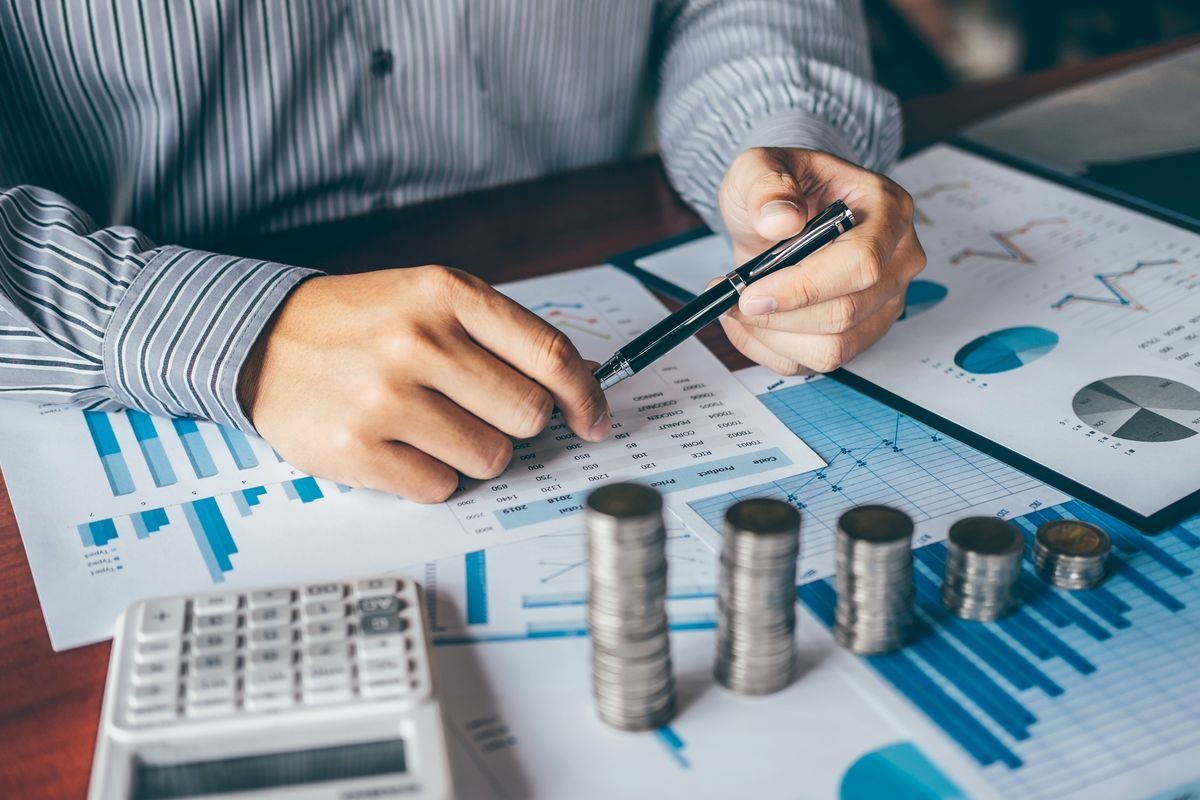 Businessman accountant counting money and making notes at report doing finances and calculate about cost of investment and analyzing financial data, Financing Accounting Banking Concept.